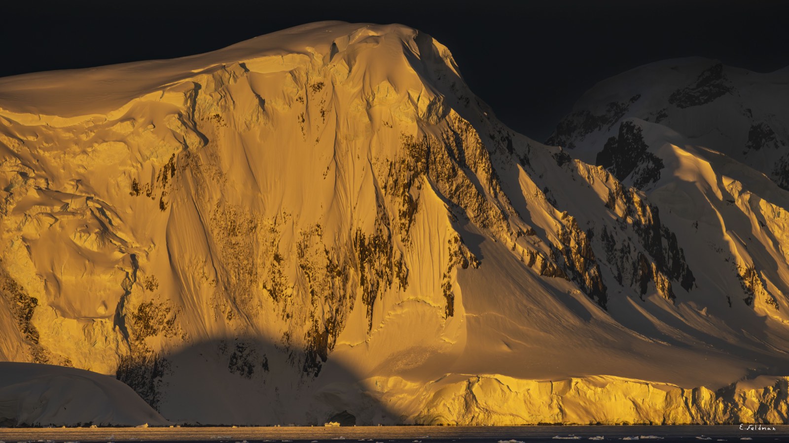 A mountain face lit gold at sunset