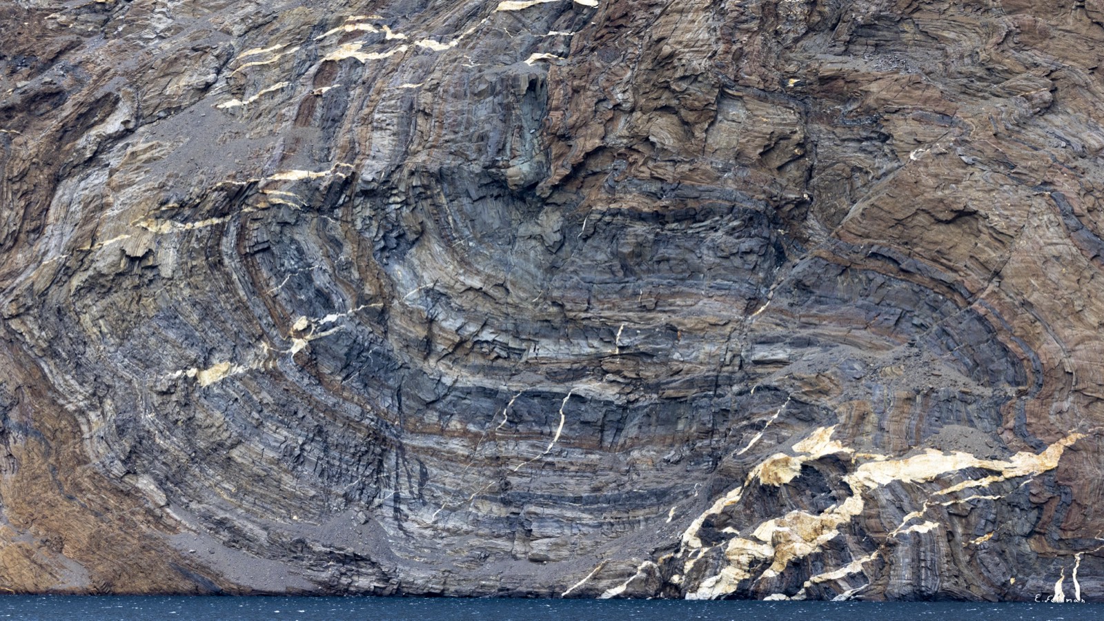 Folded rock strata on a Greenland cliff