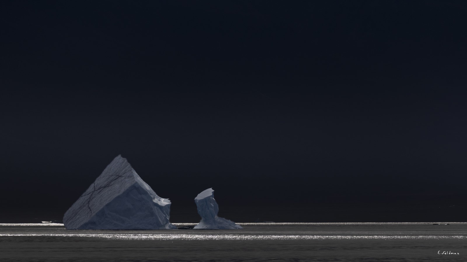 A pyramid-shaped iceberg in the dark