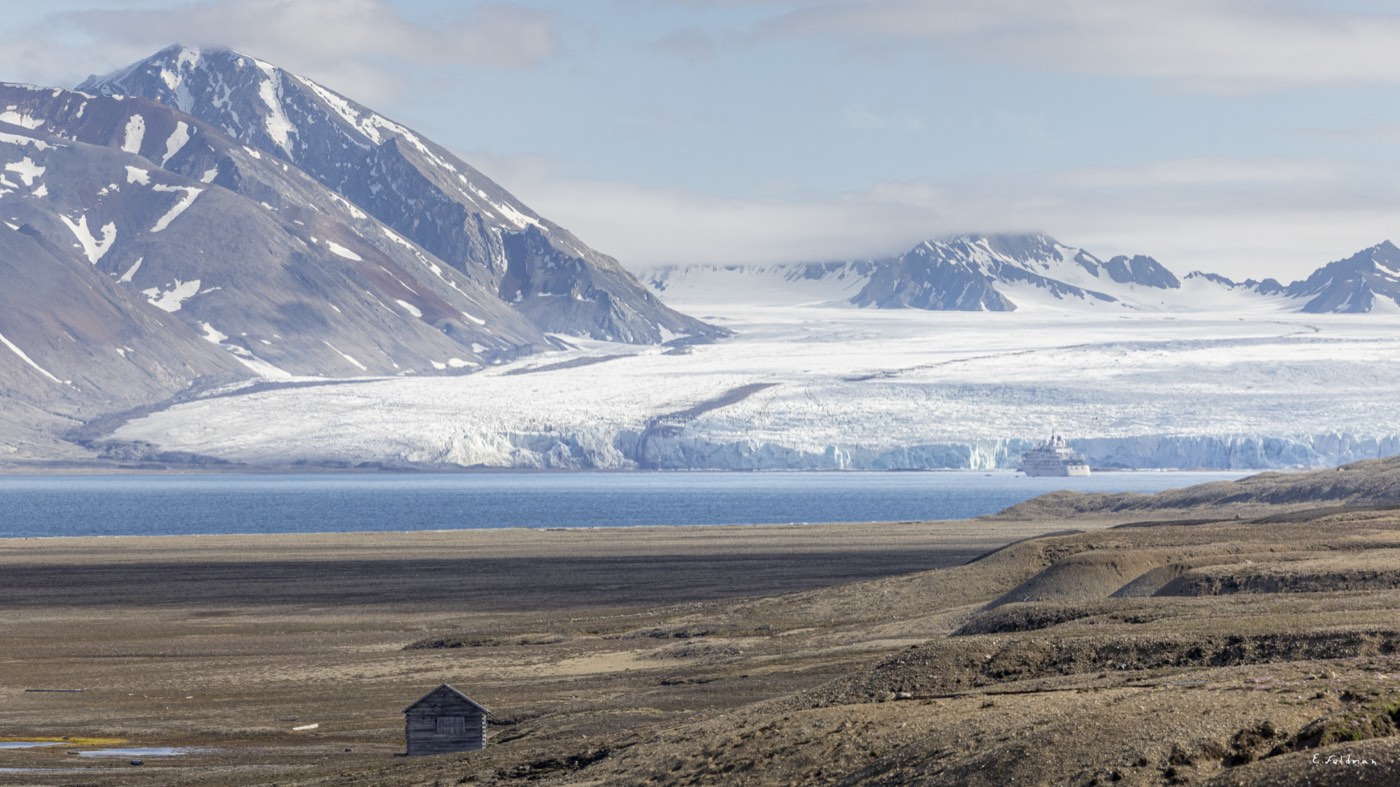 A lone cabin facing a glacier in Svalbard
